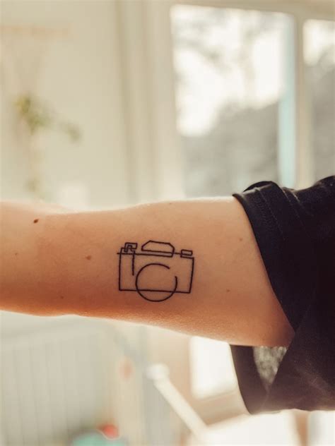 A Person Amp 39 S Arm With A Camera Tattoo On The Left Side Of Their Arm